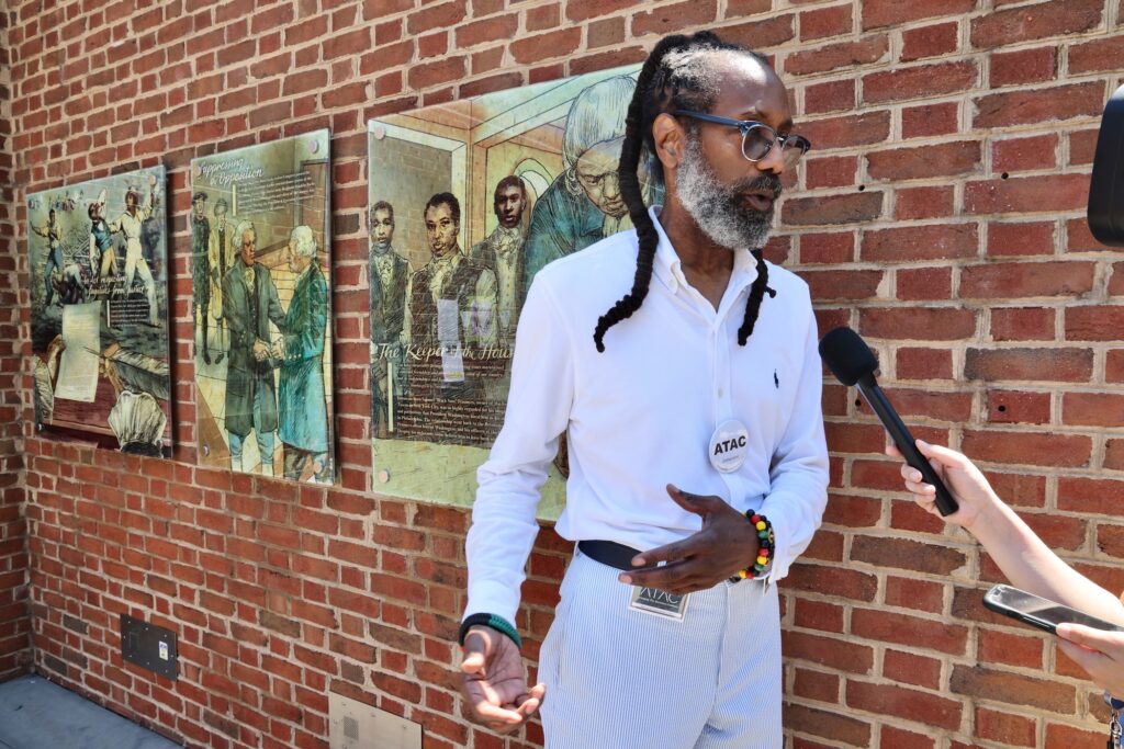 Michael Coard, founder of the Avenging the Ancestors Coalition, talks with reporters at the President's House Site