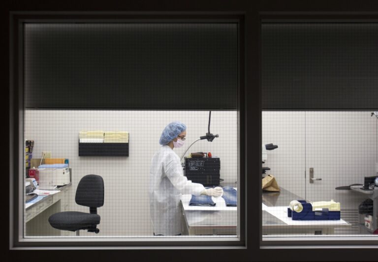 In this Friday, March 2, 2012 photo, Allyson Goble, a forensic scientist at the New York State Police Forensic Investigation Center in Albany, N.Y., screens a pair of blue jeans for biological evidence.