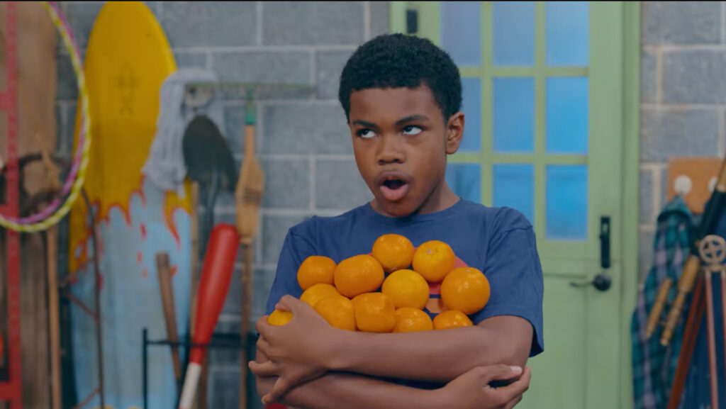 GNC Good Neighbor Club cast member holding oranges
