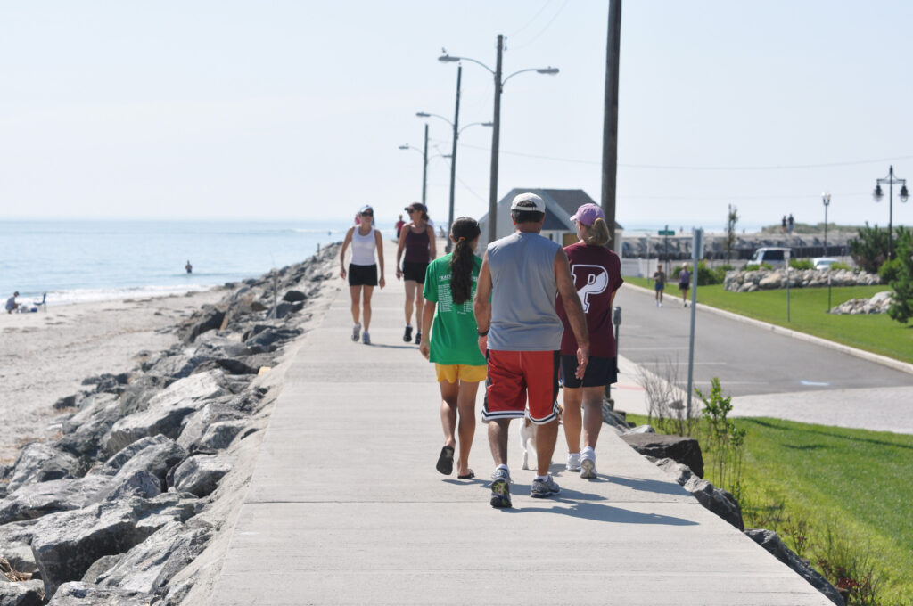 North Wildwood Seawall – Photo Credit Greater Wildwoods Tourism Improvement and Development Authority A family walks along the boardwalk next to the beach.