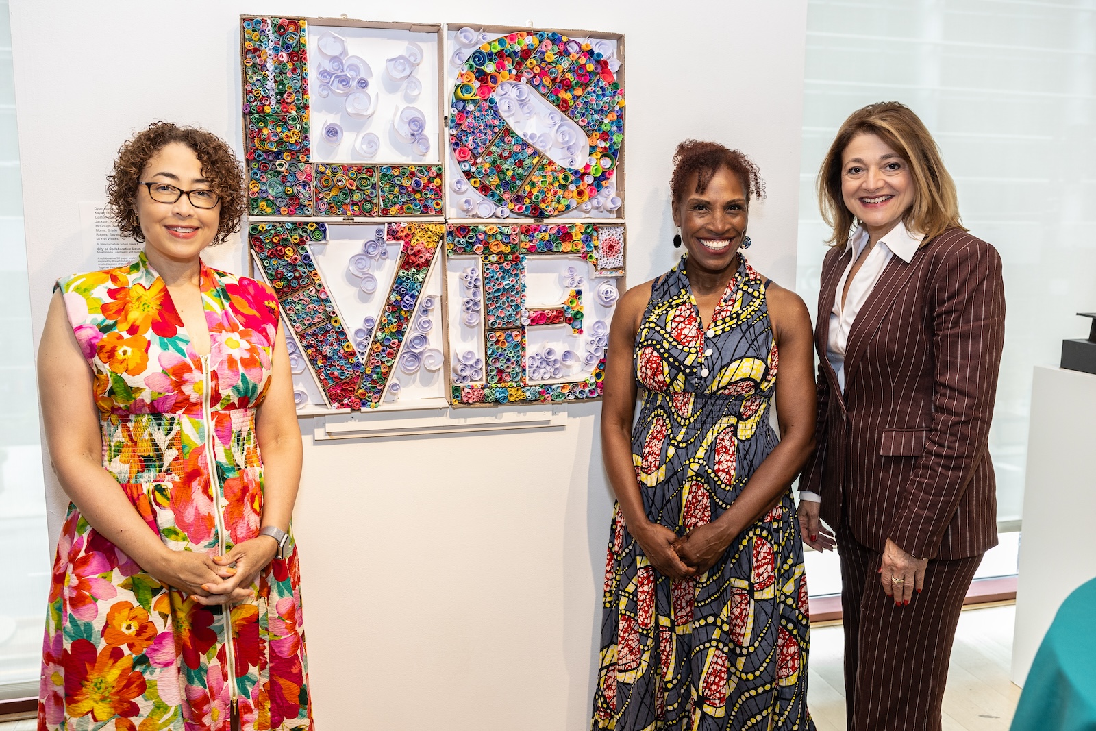 Keisha Jordan, president and CEO of Children's Scholarship Fund Philadelpha, stands in front of "City of Collaborative Love" by eighth graders at St. Malachy Catholic School, with Philadelphia Chief Cultural Officer Val Gay and president and CEO of Independence Mission Schools Giana D'Angelo.