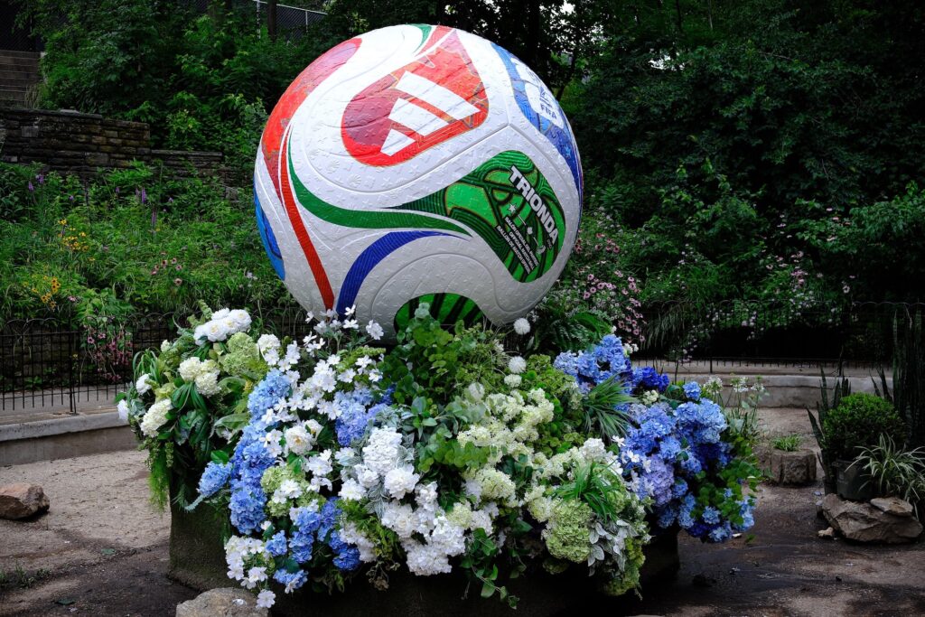A large sculpture of a FIFA soccer ball surrounded by flowers.
