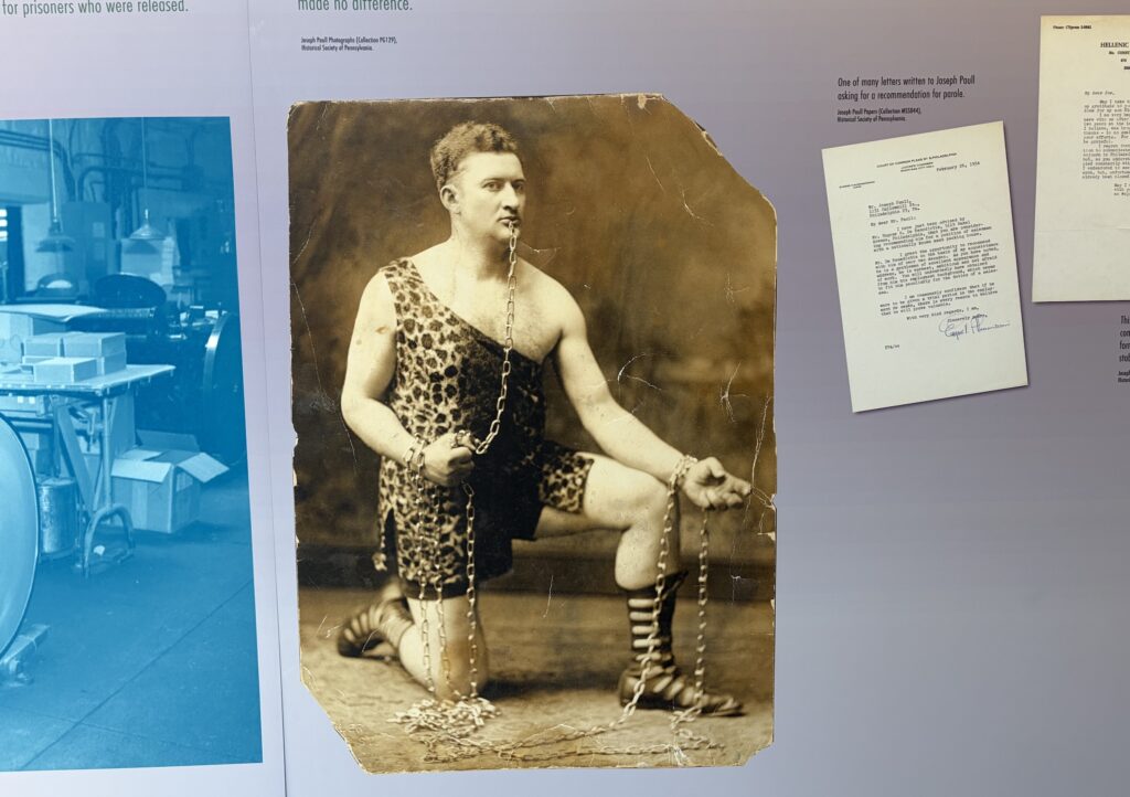 Hanging on the wall in the exhibit is an archival photo of Joseph Paull posing in his circus strongman attire.