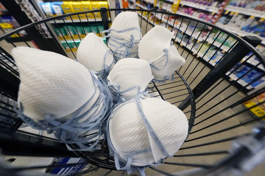FILE - A product stall filled with free N95 respirator masks, provided by the U.S. Department of Health and Human Services, sits outside the pharmacy at this Jackson, Miss., Kroger grocery store, Wednesday, Feb. 2, 2022. (AP Photo/Rogelio V. Solis)