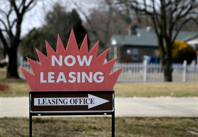a sign reads NOW LEASING and points to a leasing office