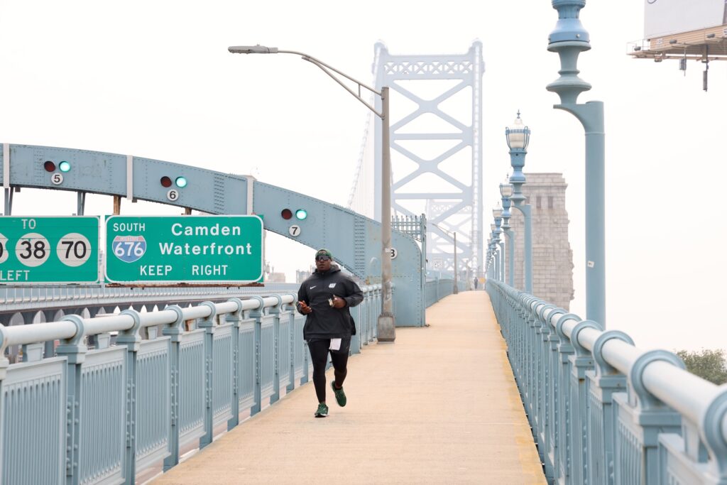 2026 07 17-e lee-philadelphia-wildfire smoke jogger Tarir Satterfield-Rowe of Camden jogs across a smoke shrouded Ben Franklin Bridge