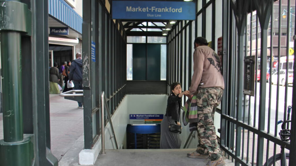 11th-street-station-philadelphia-file a woman gives change to a man
