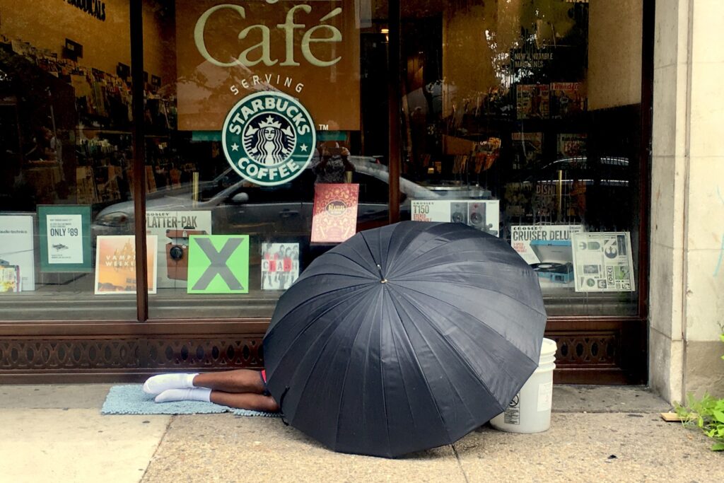 2018 08 21-e lee-rittenhouse square-homeless man under umbrella a person sleeping on the sidewalk, under an umbrella