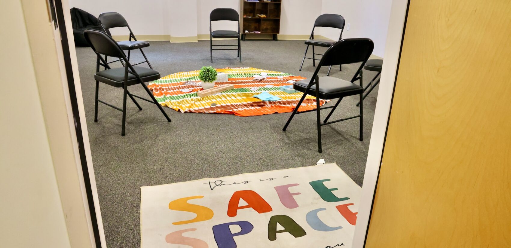 a rug reads THIS IS A SAFE SPACE TO BE WHO YOU ARE