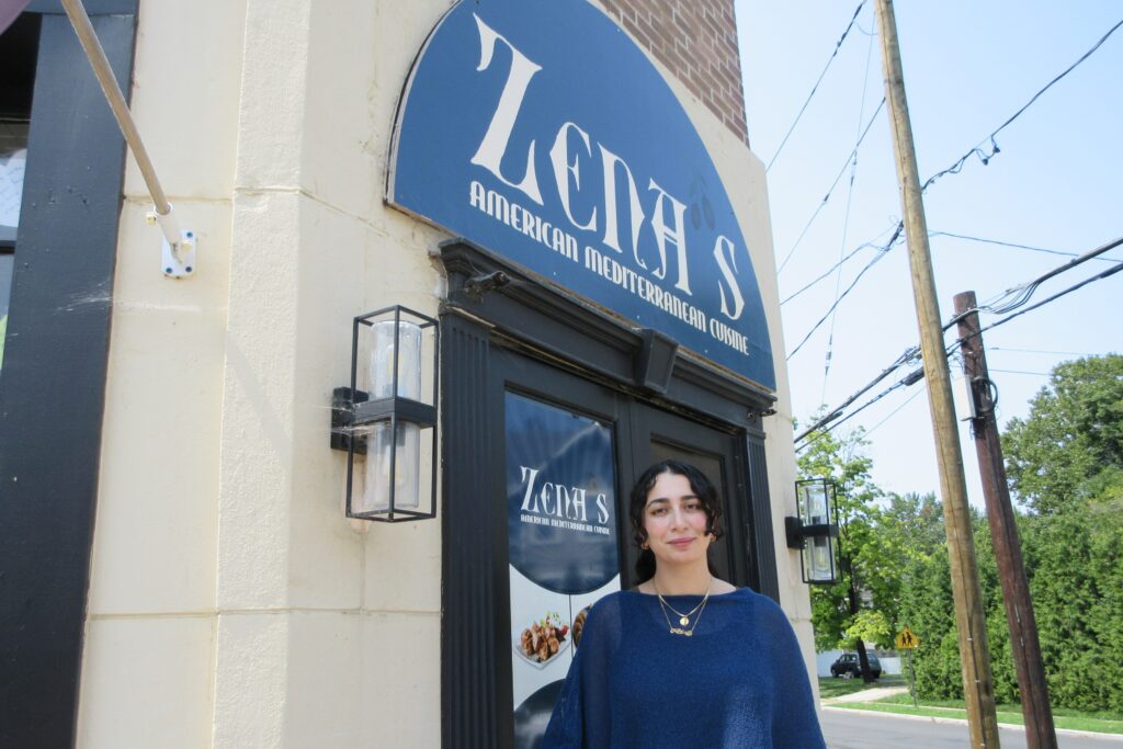 2026 08 12 k burns Zena Saifo at restaurant entrance-cropped Zena Saifo stands in front of the restaurant Zena's American Mediterranean Cuisine