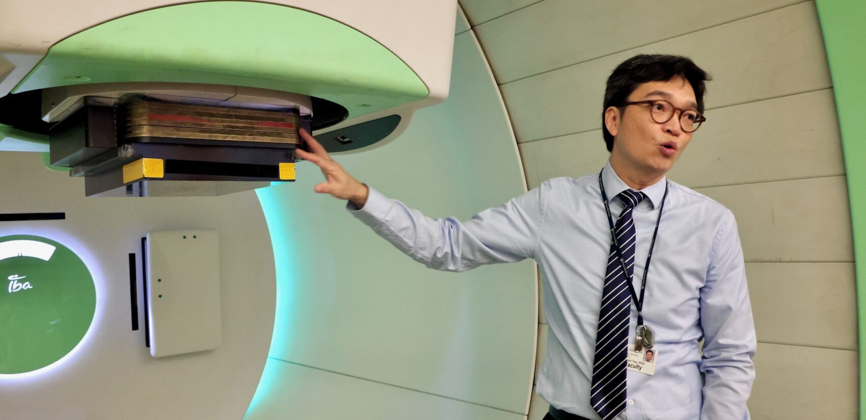 Kevin Teo speaking in front of the FLASH cancer-killing radiation therapy machine
