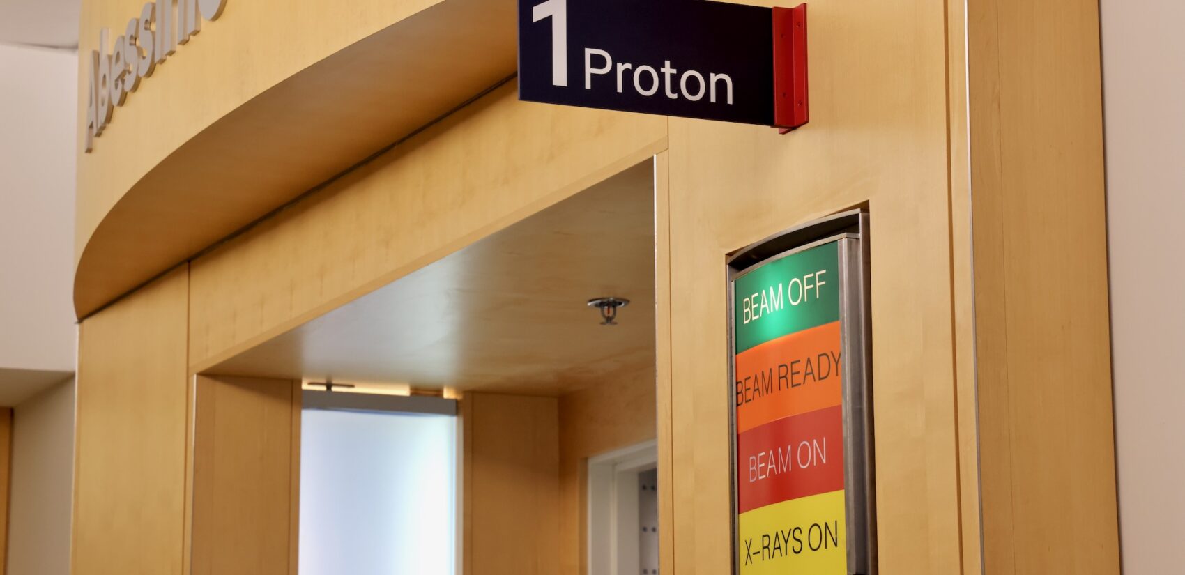 a sign reads 1 Proton, and one under reads BEAM OFF, BEAM READY, BEAM ON, X-RAYS ON