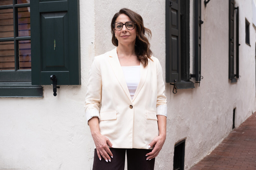 Emily-Mello-mural-arts-philadephia Emily Mello, the new executive director for Mural Arts Philadelphia, wears a white suit and black pants in front of a building