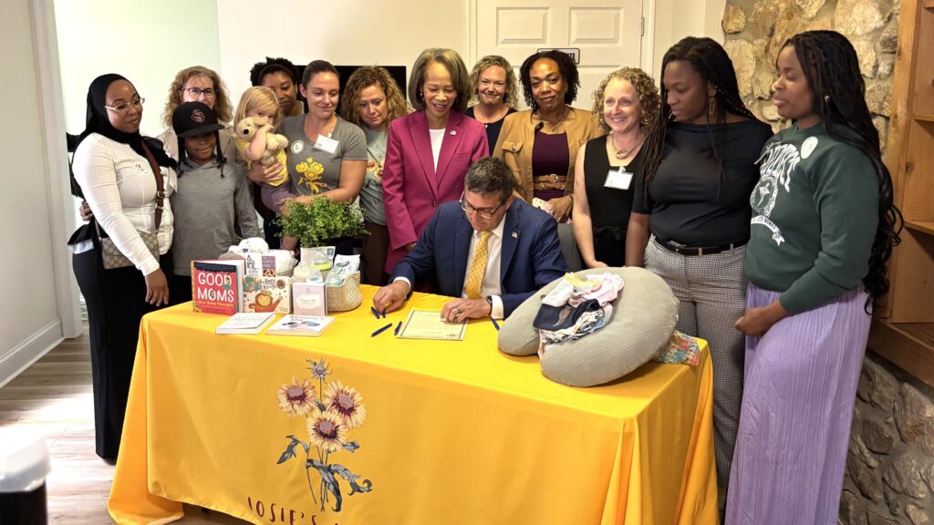 Meyer maternal health-2026 Matt Meyer signs legislation surrounded by standing women