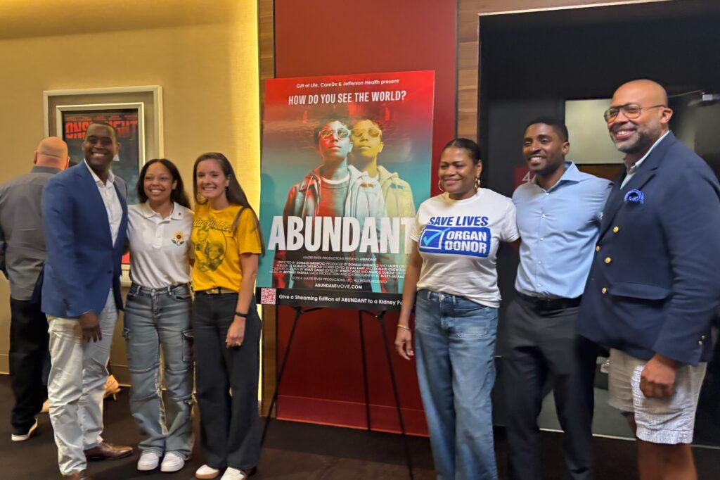abundant-documentary-organ-donation People standing next to a poster for the documentary Abundant