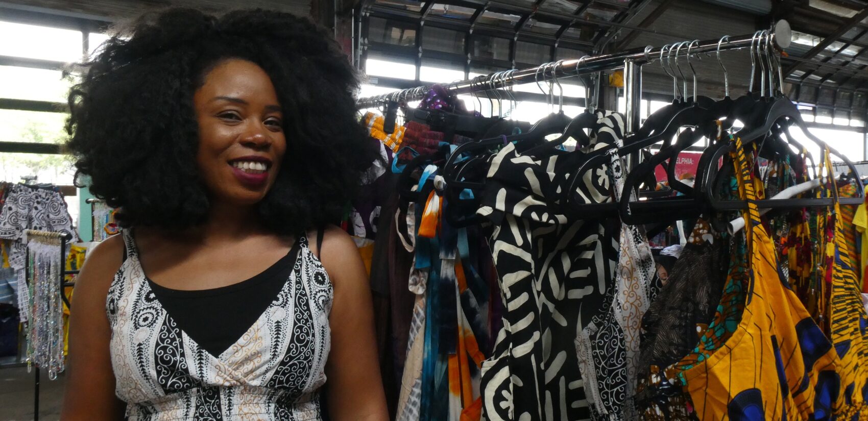 Rose Dousuah smiles next to a rack of clothes