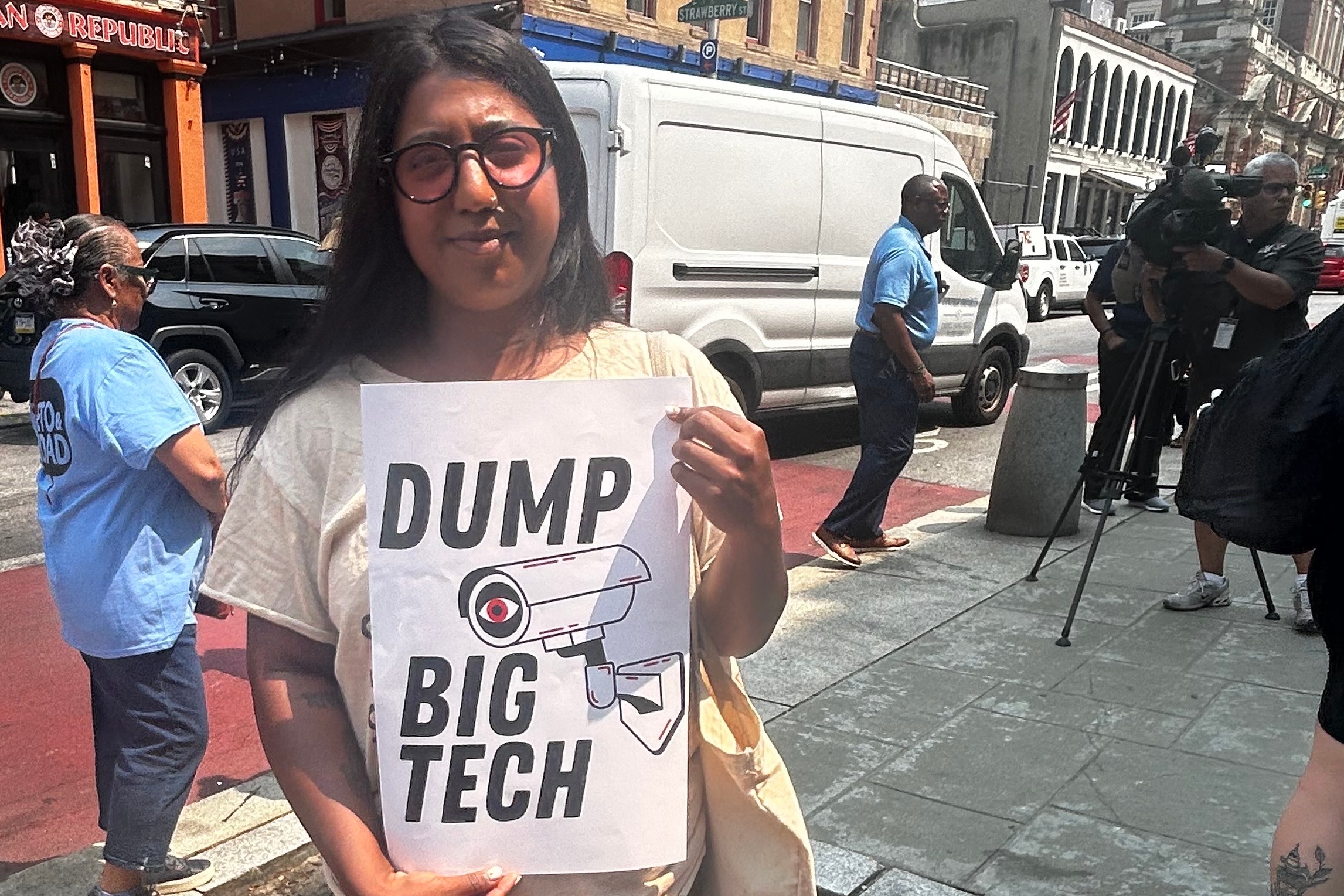 Sharmin Hossain holds a sign reading DUMP BIG TECH
