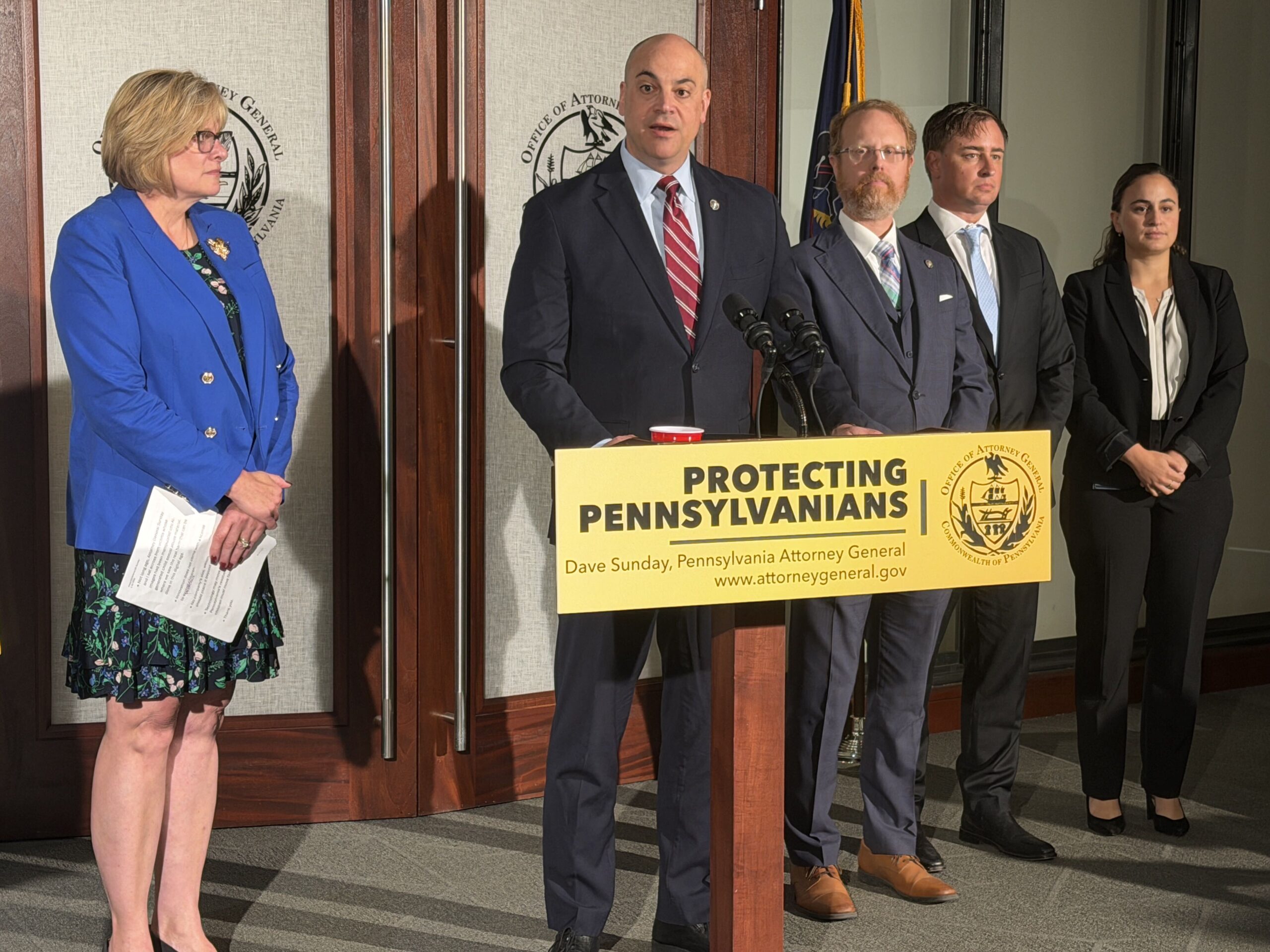Dave Sunday speaks at a press conference alongside others, including Tracy Pennycuick