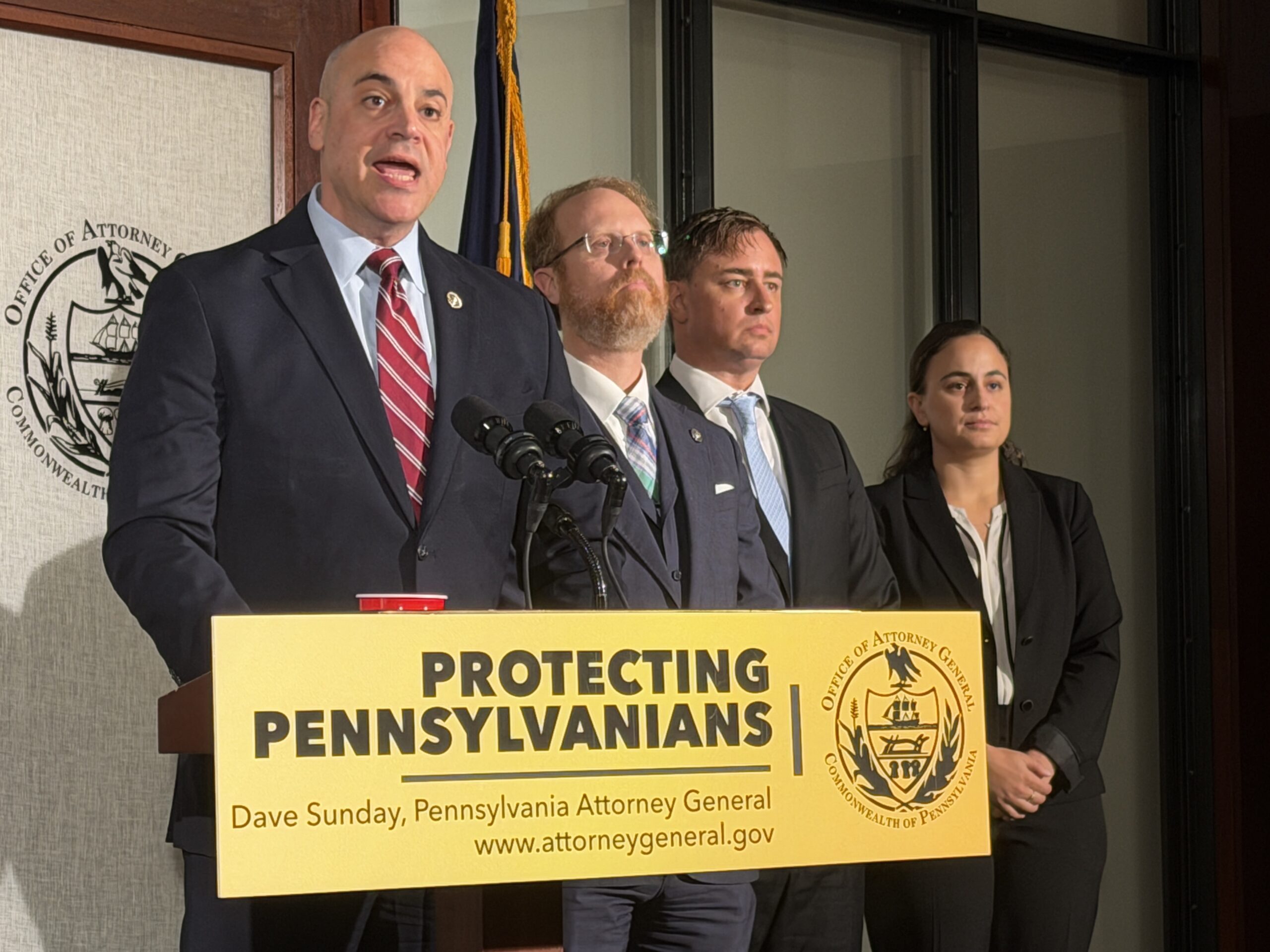 Dave Sunday speaks at a press conference alongside others