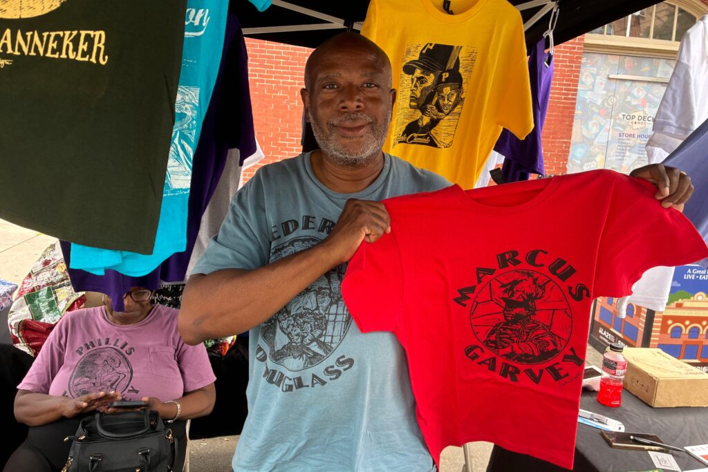 freedom-now-festival-2026-08-02-1 Sean Ramon Montague holds a Marcus Garvey shirt he made