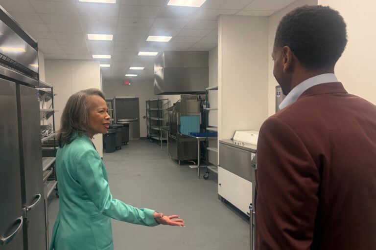 Lisa Blunt Rochester talking to Logan Herring in a kitchen