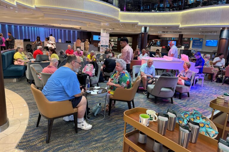 Passengers at tables in the central atrium of the Norwegian Jewel cruise liner