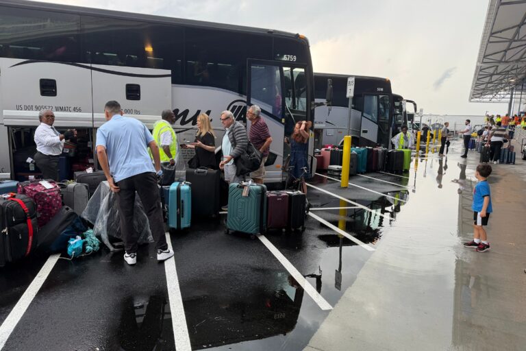 Passengers grabbing luggage off of a bus