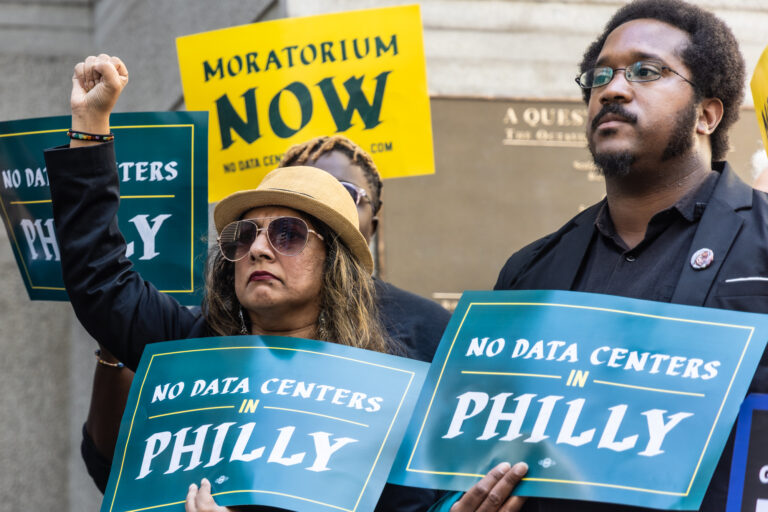 two people hold signs reading NO DATA CENTERS IN PHILLY, and a sign behind them reads MORATORIUM NOW