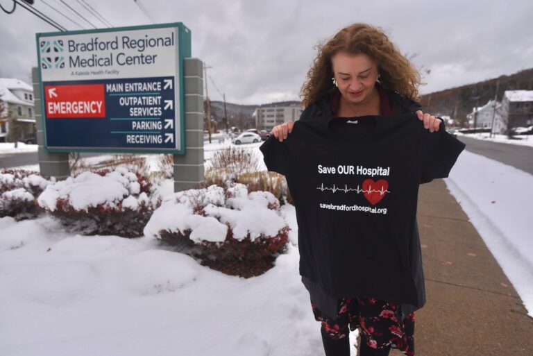 Margie Brown, a native of Bradford, PA, holds up a T-shirt that says “Save Bradford Hospital.” The local grassroots group of the same name was dedicated to advocating for the return of Bradford Regional Medical Center as a full-service hospital and securing better healthcare access for the community.
