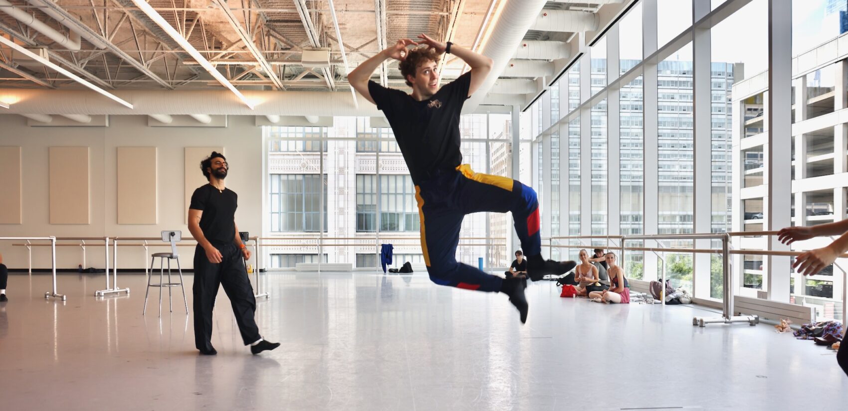 A ballet dancer is seen mid-air as he leaps and clicks his heals.