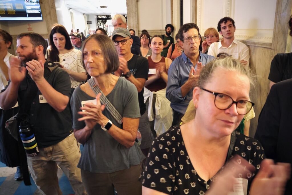 Protesters gather at City Hall during a rally to save the Academy of Natural Sciences