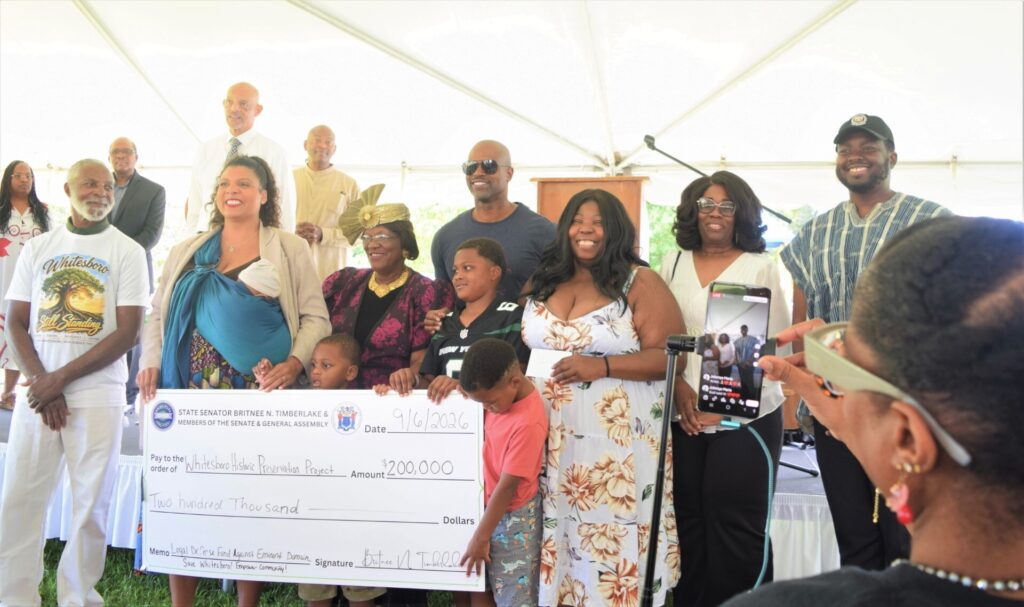 People hold up a giant check
