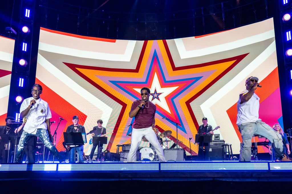 Boyz II Men perform on stage, with a multicolored star behind them, in Nashville, Tennessee