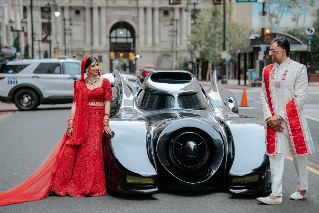 bride-groom-batmobile-replica-bp-092526 Bride Rishika Chauhan and groom Dhruv Padodara pose next to a replica of the 1989 Batmobile