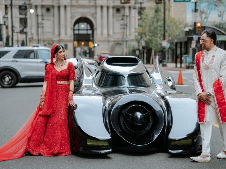 bride-groom-batmobile-replica-bp-092526 Bride Rishika Chauhan and groom Dhruv Padodara pose next to a replica of the 1989 Batmobile