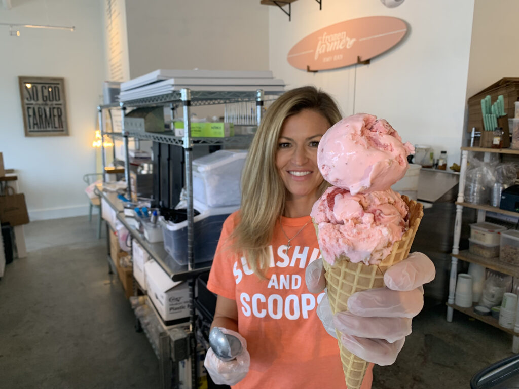 The Frozen Farmer founder Katey Evans holds up a freshly scooped ice cream cone at the company's new Dewey Beach location