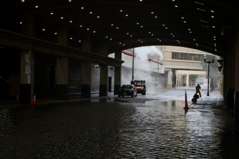 Flooded roadways under a tunnel, with a person wading through water in the distance in Atlantic City, New Jersey