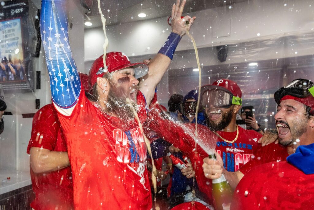 Philadelphia Phillies first baseman Bryce Harper, left, is doused by Garret Stubbs, right, during a celebration in the clubhouse after the team clinched a Wild Card slot in the postseason by defeating the Tampa Bay Rays in a baseball game Sunday, Sept. 27, 2026, in Philadelphia.