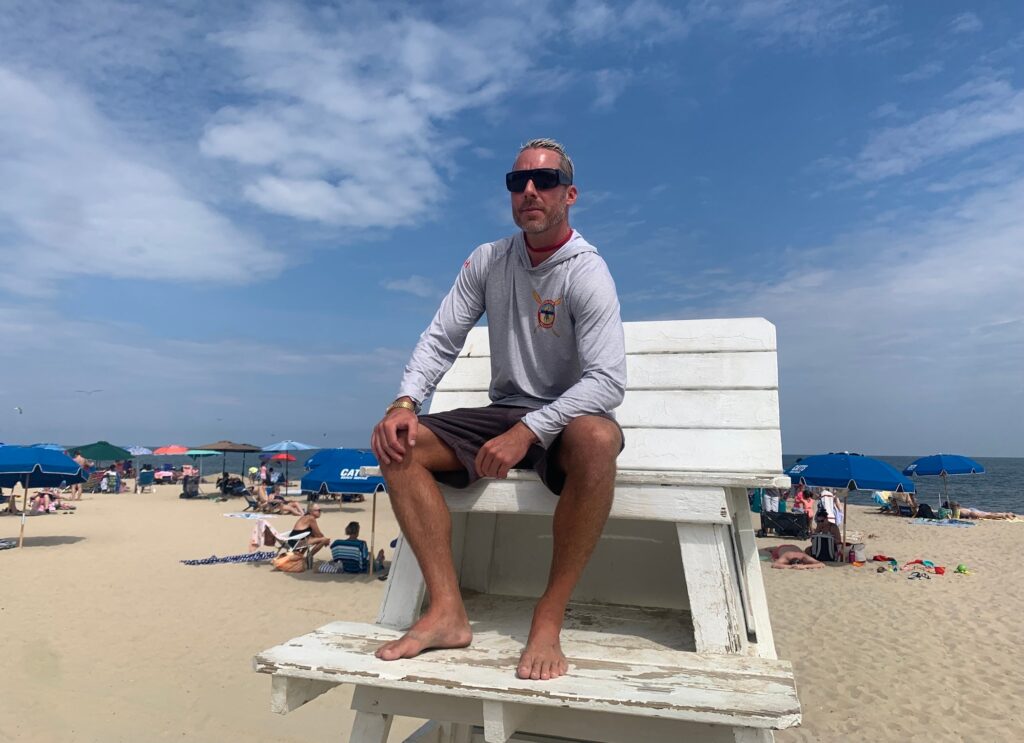 Ben Schweers está sentado en la silla de salvavidas frente a la sede de la Patrulla de Playa de Rehoboth
