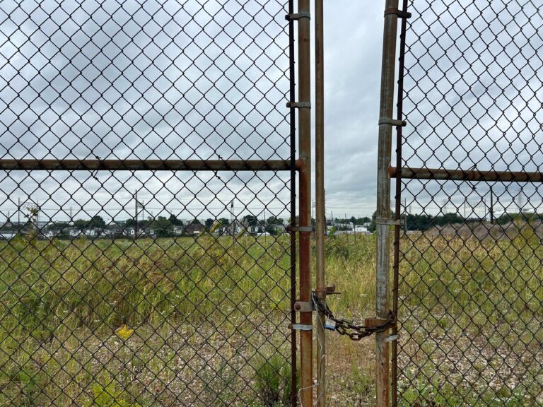 a vacant site behind a gate