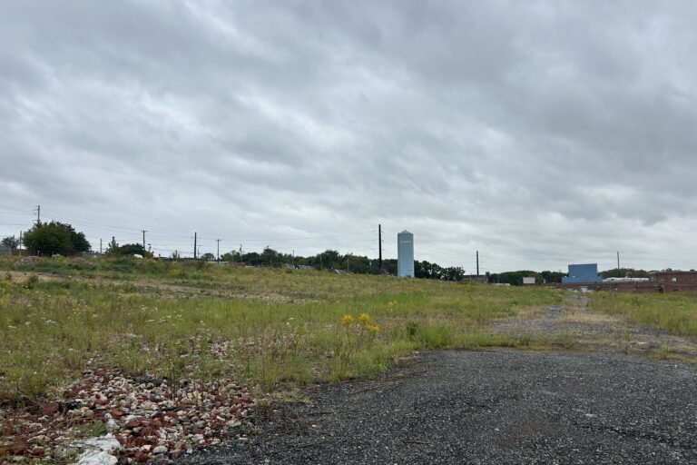 a vacant site of grass and gravel