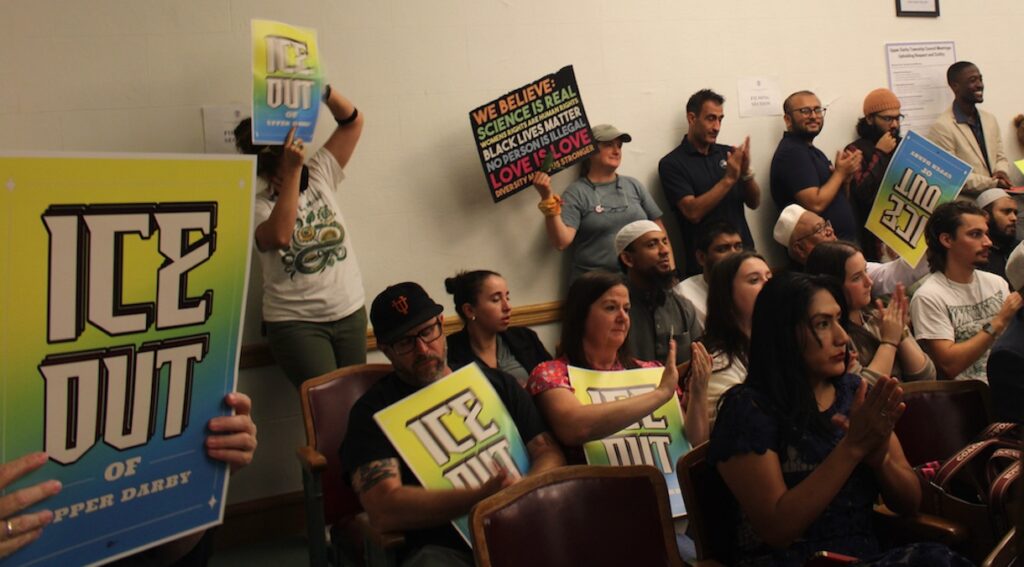 upper-darby-ice-legislation-2 Residents holding signs reading ''ICE out of Upper Darby' clap as an ordinance is passed by Township Council that limits collaboration with U.S. Immigration and Customs Enforcement
