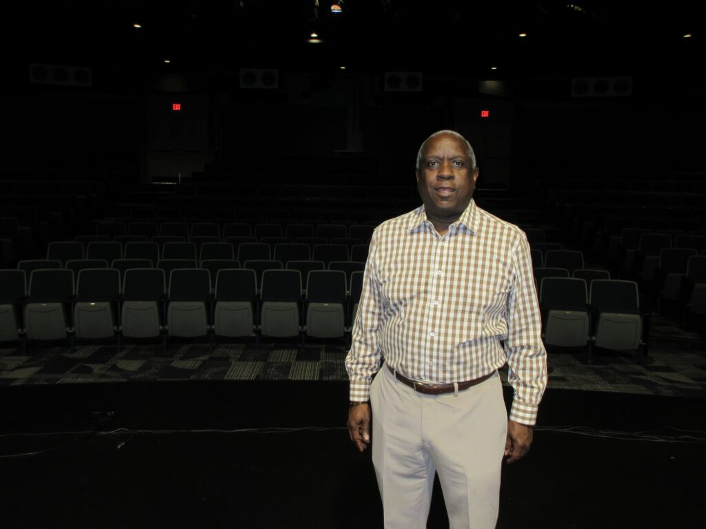 2026 09 30 k burns_bobby duckkett on stage at the willingboro performing arts center Bobby Duckett is standing on stage at The Willingboro Performing Arts Center, with a spotlight on him.