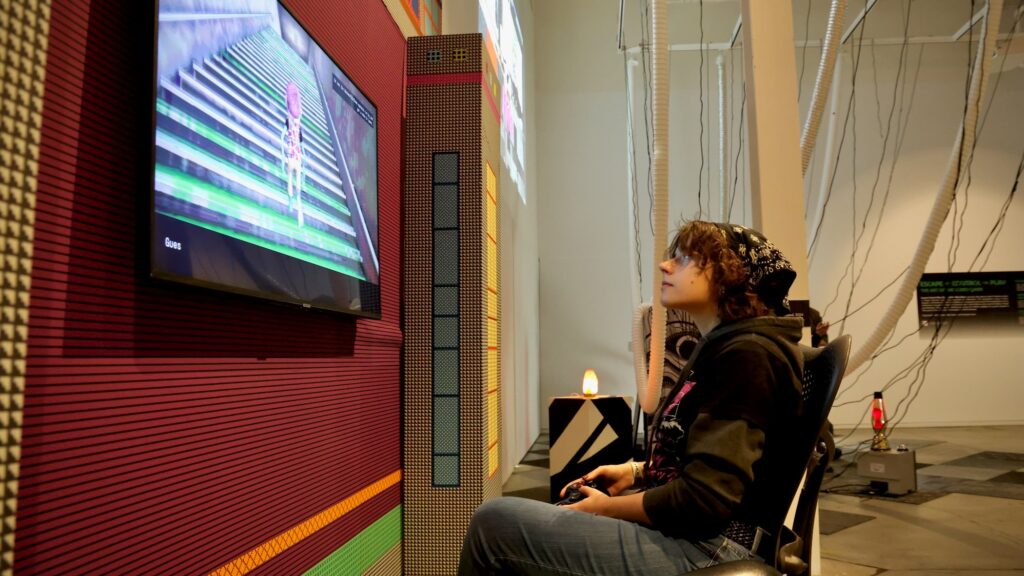 2026 10 08-e lee-corrina mullins-philadelphia drexel pearlstein gallery-art of the video game escape from lavender island Corrina Mullins playing a video game