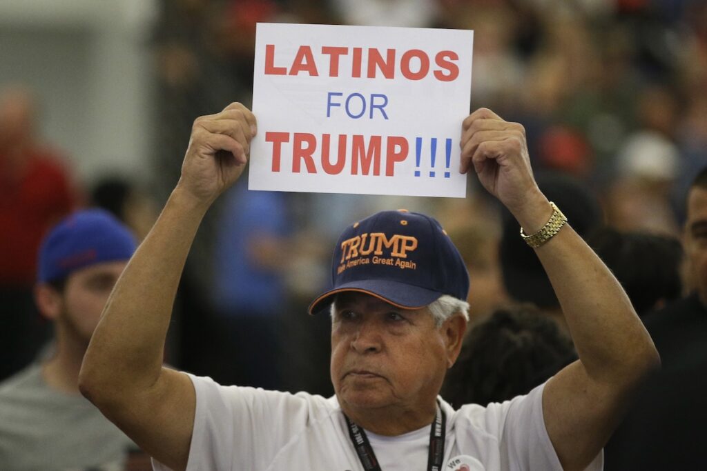 Latino Vote A Hispanic man holds up a sign for Republican presidential candidate Donald Trump before the start of a rally at the Anaheim Convention Center, Wednesday, May 25, 2016, in Anaheim, Calif. (AP Photo/Jae C. Hong)