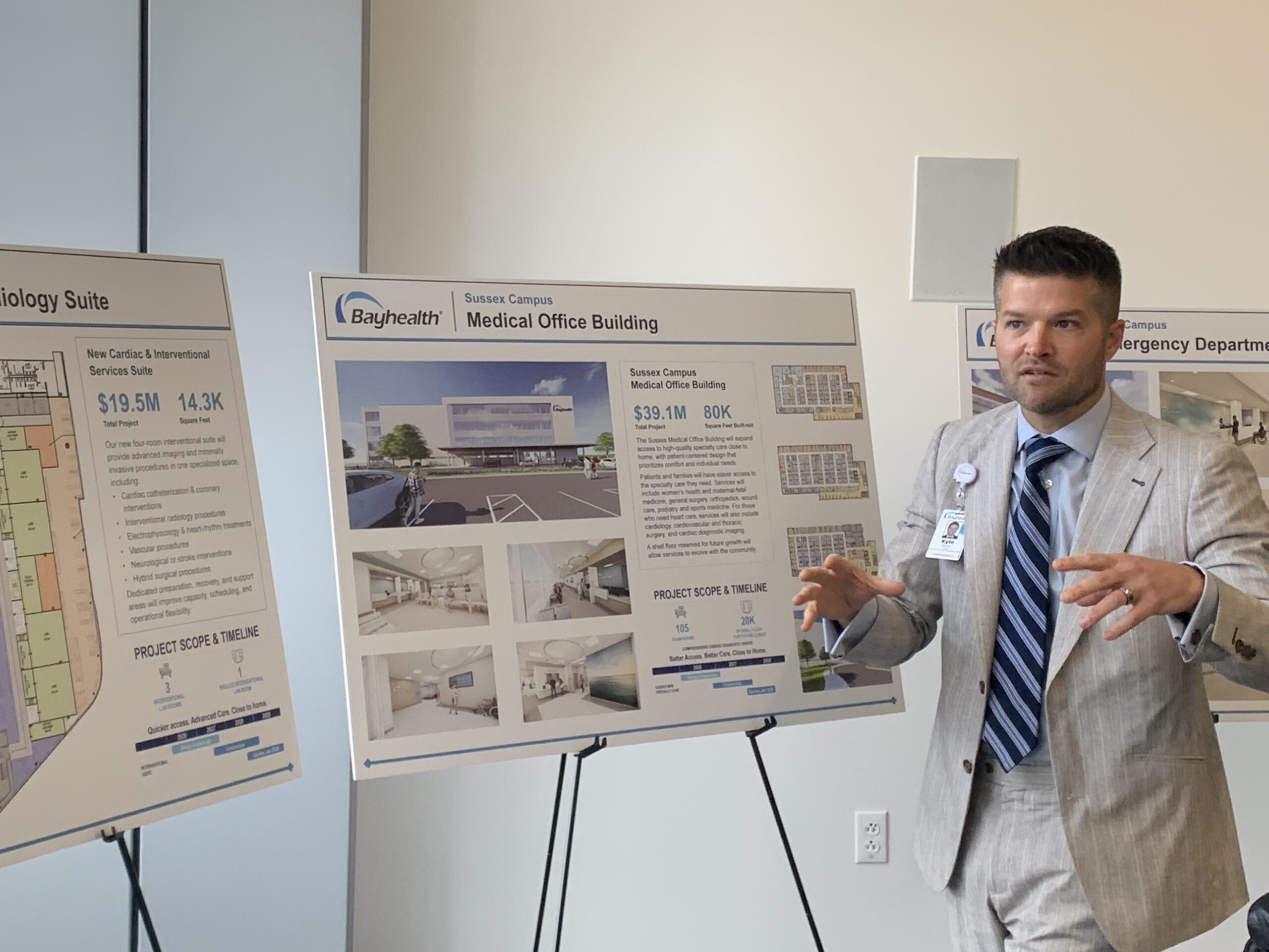 Kyle Benoit speaks with diagrams behind him