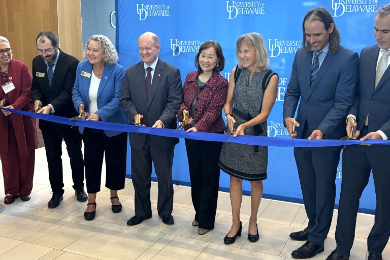 Chris Coons and University of Delaware officials cutting a ribbon