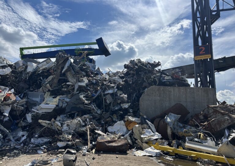 At the EMR scrap metal facility in Camden, heaps of scrap metal are stacked very high. A sign shows what the allowable height limit is.