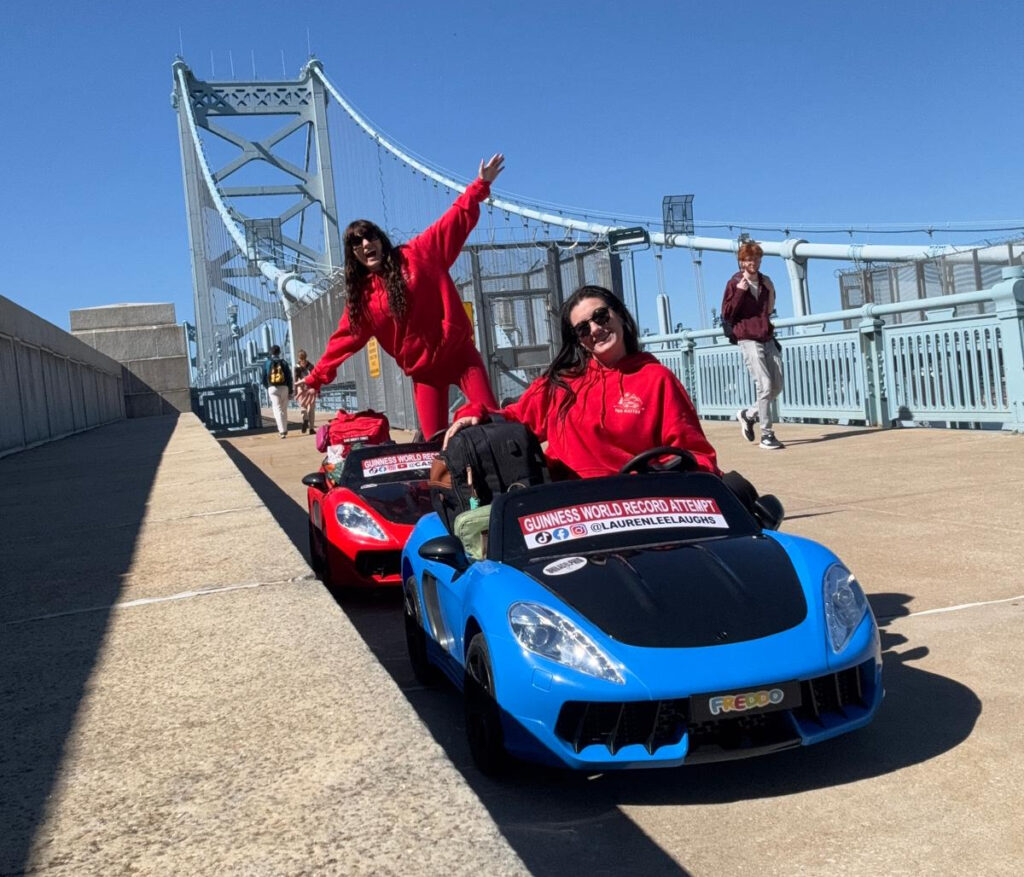 influencers-toy-car-ben-franklin-bridge-bp-102926 Social media influencers Cassie Aran (left) and Laura Lee pose on the Benjamin Franklin Bridge