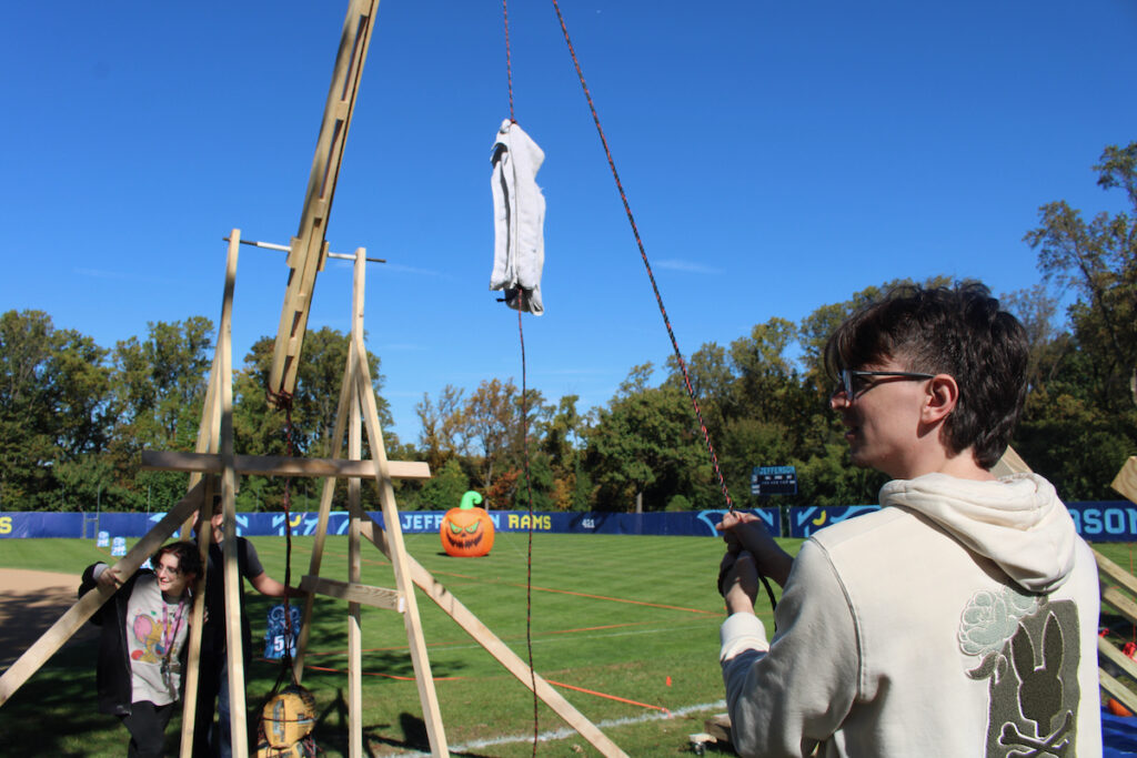 A university student gets a pumpkin catapult ready